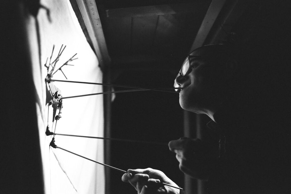 a woman holding a bunch of sticks in front of a window